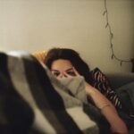woman in black shirt lying on bed
